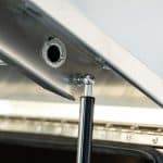 Close-up of gas strut mount and welded joint inside aluminium canopy