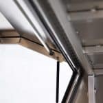 Inside view of an Oz Chivalry X1-1800 F/P 3 Doors Black UTE canopy showing the gas strut and internal frame design